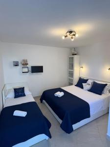 a bedroom with two beds and a tv on the wall at The View in Vinišće