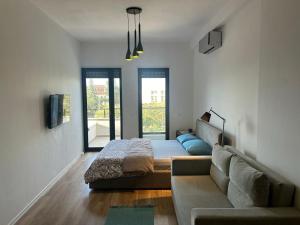 a living room with a couch and a bed at Katoria Bridge Apartment in Vlorë