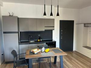 a kitchen with a wooden table and a dining room at Katoria Bridge Apartment in Vlorë