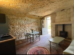 a living room with a table and a fireplace at La petite Troglo in Aubigné-Racan