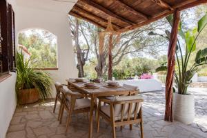 an outdoor dining room with a wooden table and chairs at Villa Maison Rosabianca - Costa Smeralda by Rosabianca Collection in Cugnana Verde