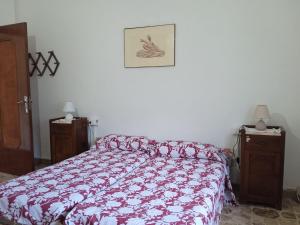 a bedroom with a bed with a red and white comforter at Appartamento Il Salice in Carignano