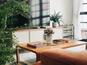 een woonkamer met een tafel met boeken en planten bij Casa Palm Spring in Bangkok