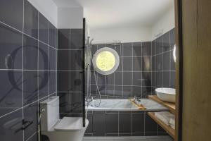 a bathroom with a tub and a toilet and a sink at Chic Studio Disneyland Paris in Montévrain