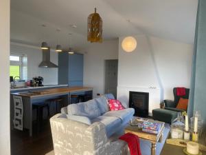 a living room with a couch and a kitchen at West Cork holiday home with incredible sea views in Donoure