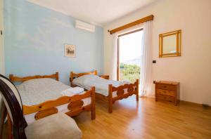 a bedroom with two beds and a window at ΕΥΡΥΧΩΡΟ ΣΠΤΙ στη Μαγουλα in Magoúla