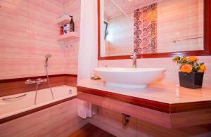 a bathroom with a white sink and a bath tub at ΕΥΡΥΧΩΡΟ ΣΠΤΙ στη Μαγουλα in Magoúla