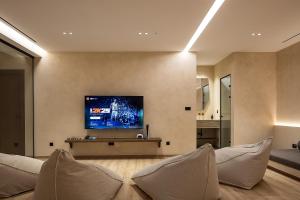 a living room with a flat screen tv on a wall at Ormus Villa - Beachfront Sanctuary Blending with Earth, Sun & Sea by etouri in Panormos Rethymno