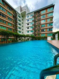 a large swimming pool in front of a building at Tessa Estates Condo one ThongLor Bangkok in Bangkok