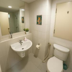 a bathroom with a toilet and a sink and a mirror at Tessa Estates Condo one ThongLor Bangkok in Bangkok
