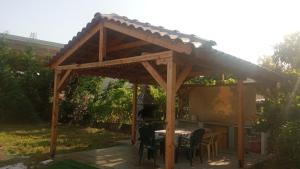 a wooden gazebo with a table and chairs at Elea House in Keramoti