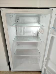 an empty refrigerator with its door open with its door open at Estudio Caballo-Piscina in Denia