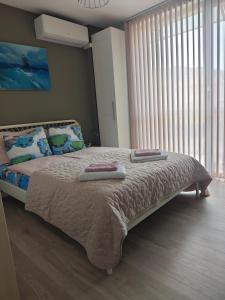 a bedroom with a bed with two towels on it at Central, brand new apart with parking in Blagoevgrad