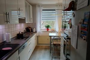 a kitchen with white cabinets and a sink and a window at Private Rooms in Hannover