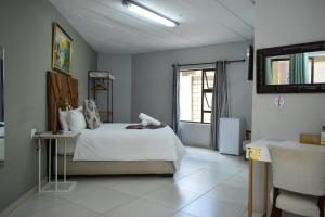 a bedroom with a white bed and a window at Protea Guesthouse in Newcastle +34 photos