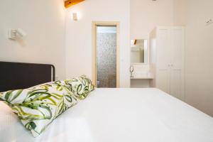 a bedroom with a white bed with a pillow on it at Skriveni dragulj - A Peaceful Oasis with a Sea View in Trogir +32 photos