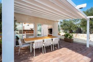 a patio with a wooden table and chairs at Skriveni dragulj - A Peaceful Oasis with a Sea View in Trogir