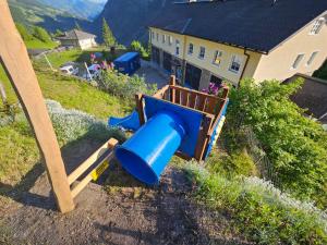 a blue slide in a yard next to a house at Haus Traumhorst in Heiligenblut