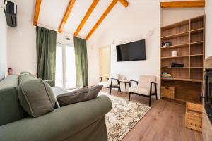 a living room with a couch and a tv at Skriveni dragulj - A Peaceful Oasis with a Sea View in Trogir