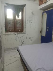a dirty room with a window and a table at TKM homestay in Tiruvannāmalai