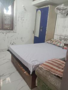 a bed in a room with a blue door at TKM homestay in Tiruvannāmalai