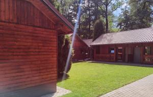 a red brick building with a grass yard at Bajkowa Przystań in Pokrzywna