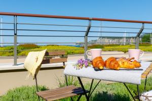 a table with bread and croissants on a balcony at Portopiccolo Apartments - Giardino vista castello in Portopiccolo Sistiana