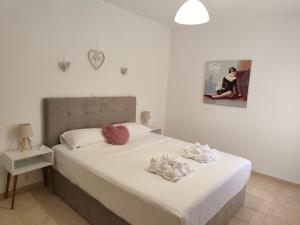 Un dormitorio con una cama con dos animales de peluche encima. en Breezy Dream, Corfu, en Corfú