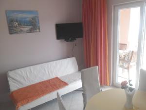 a living room with a white couch and a table at Apartments Dunja Piric in Lopar