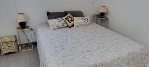 a bedroom with a white bed with two night stands at La bonne adresse in Woippy