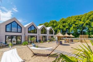 a house with a hammock in front of it at Lulu Holiday Resort domki z podgrzewanym Basenem in Mielno