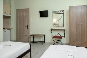 a room with two beds and a tv on the wall at Konstantinos Hotel & Apartments 2 in Nydri