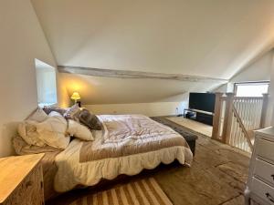 a bedroom with a large bed in a attic at Maison de Saint Ours in Moye