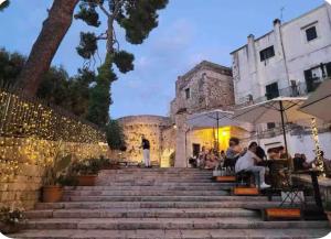 a group of people sitting on the stairs of a building at Sweet home A&C in Conversano