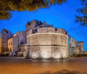 a castle sitting in water in front of a building at Sweet home A&C in Conversano +4 photos