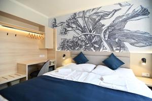 a bedroom with a bed with a drawing on the wall at Hotel Merlot in Eger