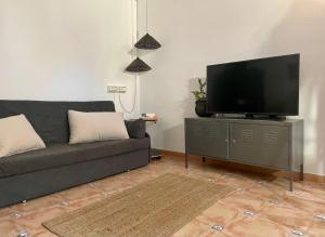 a living room with a couch and a flat screen tv at Apartamento en villa bellavista in Almerimar