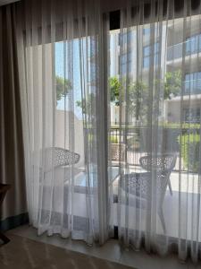 a room with a window with a table and chairs at Address Beach Resort Fujairah Apartment Three Bedrooms by Blue World- 2 in Fujairah