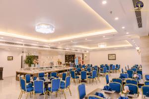 un gran salón de banquetes con sillas y mesas azules en New Era Hotel & Spa Ha Long, en Ha Long