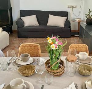 a table with plates and glasses and flowers on it at Apartamento en villa bellavista in Almerimar