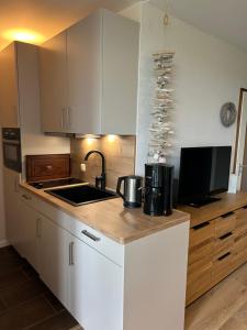a kitchen with white cabinets and a sink and a counter at Ferienwohnung Glockenberg - Westphal in Altenau +6 photos