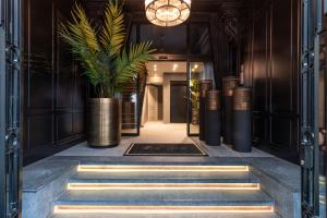 a hallway with stairs and a potted plant at Dukes' Academie Brugge - by Dukes' Hotel Collection in Bruges