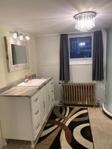 a bathroom with a sink and a mirror and a window at Townsite Comfort in Corner Brook +12 photos