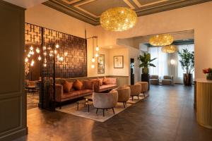 a living room with a couch and chairs and chandeliers at Dukes' Academie Brugge - by Dukes' Hotel Collection in Bruges