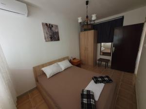 a small bedroom with a bed and a mirror at Kiwi in Ulcinj