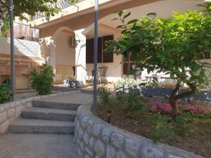 a building with stairs and a tree in front of it at Kiwi in Ulcinj