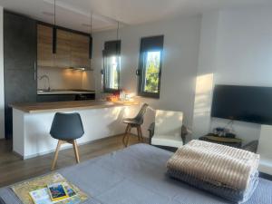 a living room with a kitchen with a couch and a table at MONGOOSE in Herceg-Novi