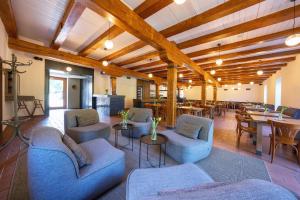 a room with blue couches and tables and wooden ceilings at Davidův mlýn in Staré Těchanovice
