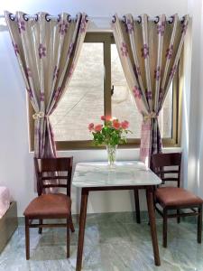 a vase of flowers on a table with two chairs at HG House in Da Nang