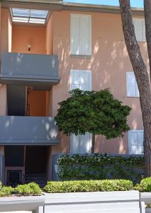 ein Gebäude mit einem Baum davor in der Unterkunft Casa Bugarini in Marcelli